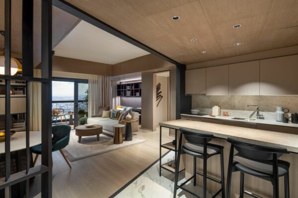 Open-plan condominium interior with a modern kitchen, dining counter, living area, and private outdoor access.
