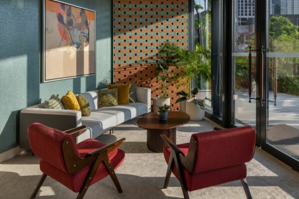 Private condominium lounge with comfortable seating, indoor plants, large windows, and access to an outdoor space