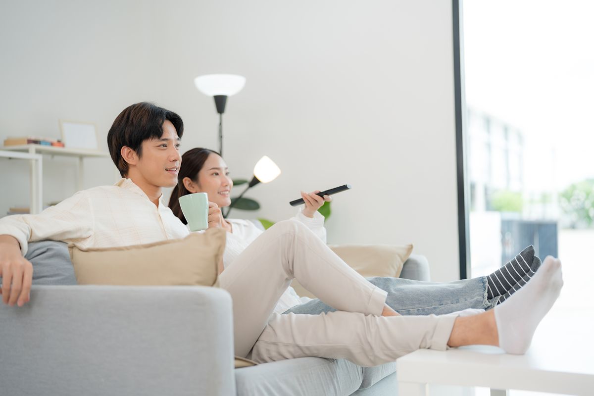 Couple relaxing together on a sofa in a bright modern condominium living room