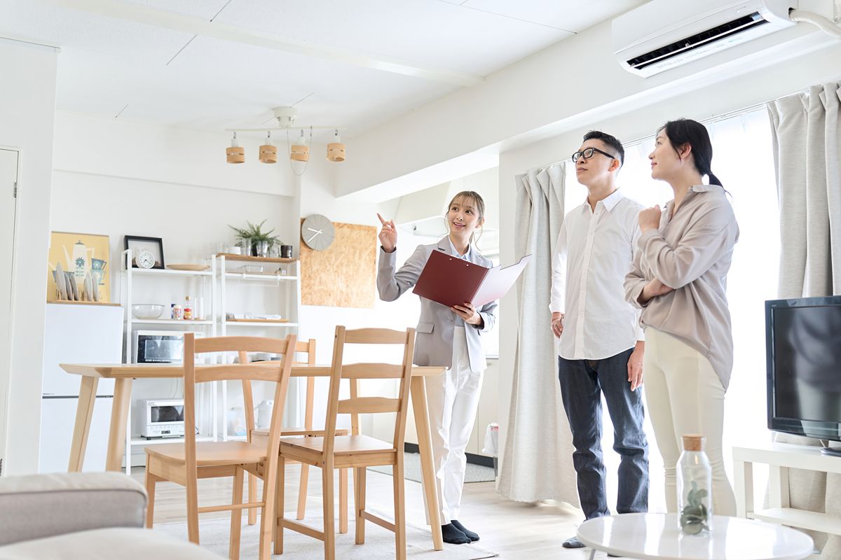 Real estate agent showing a couple around a bright condominium unit in the Philippines