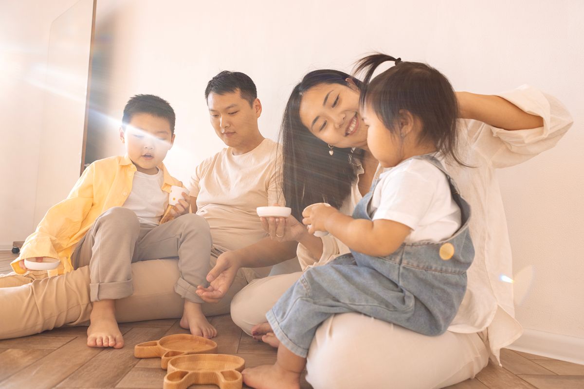 Family with two children spending time together on the floor in a bright condominium living space